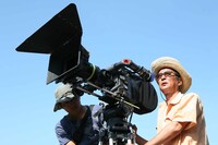 三平のトレードマークである麦藁帽を装着しての、ユニークな撮影風景。いやはやお似合いです。(c)2009「釣りキチ三平」製作委員会