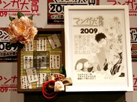 マンガ大賞2009の大賞プレートと受賞イラスト。プレートは畳とかるたをモチーフにしている。