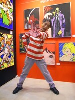 展示作品の前で得意のグワシポーズを決める楳図かずお。トレードマークの赤白ボーダーがよくお似合いですよ。