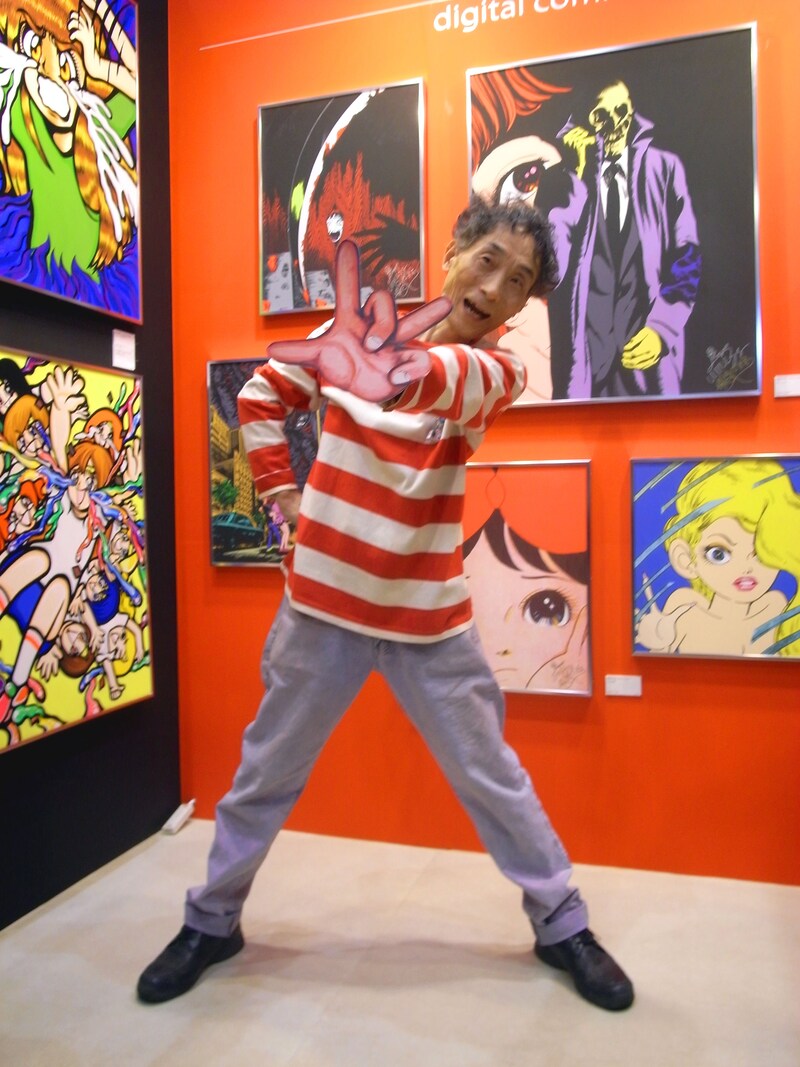 展示作品の前で得意のグワシポーズを決める楳図かずお。トレードマークの赤白ボーダーがよくお似合いですよ。