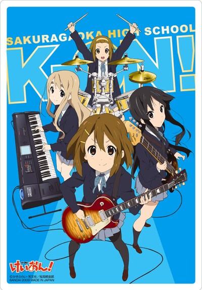 バンド「放課後ティータイム」の演奏シーンが描かれた箔押しカード。細部まで緻密に描き込まれた楽器のイラストが音楽ファンの心をくすぐる。