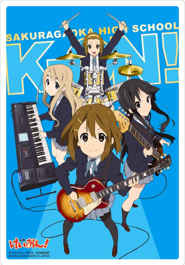 バンド「放課後ティータイム」の演奏シーンが描かれた箔押しカード。細部まで緻密に描き込まれた楽器のイラストが音楽ファンの心をくすぐる。