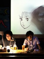 まずは往年の人気キャラ「ひばりくん」を、とのリクエストに機嫌よく描き始めるも、「ちょっと失敗しちゃった」「俺、日本で20番目くらいに上手いはずなんだ」と動揺する江口。右はスペリオール編集部の八巻氏。