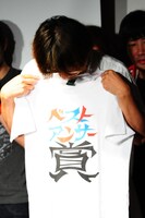 ベストアンサー賞「ジャイアント馬場の墓をあばいて骨をくう」に選ばれたしりあがりには、特製Tシャツが手渡された。