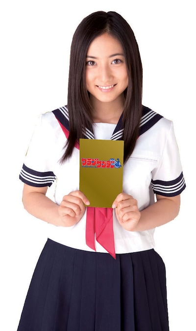 クラブサンデーキャンペーンガール紗綾。黄金に輝くロゴ入りカバーを胸に掲げ、クラブサンデーを応援。