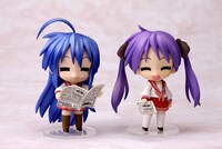 ねんどろいど泉こなた（左）と柊かがみ（右）の埼玉新聞65周年記念バージョン。新聞を読むふたり。(c)美水かがみ／らっきー☆ぱらだいす