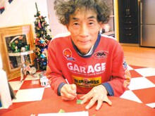 サインを彫る楳図かずお。後ろにはクリスマスツリーが。