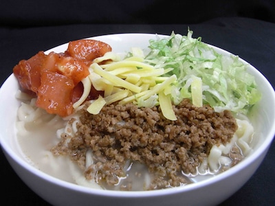 秋葉原駅前スペースにて販売される「タコスラーメン」。タコスの具材を盛ったアイデア商品だ。チーズ大盛りやハラペーニョなど有料でトッピングも可能。(C)小林 立／スクウェアエニックス・清澄高校麻雀部