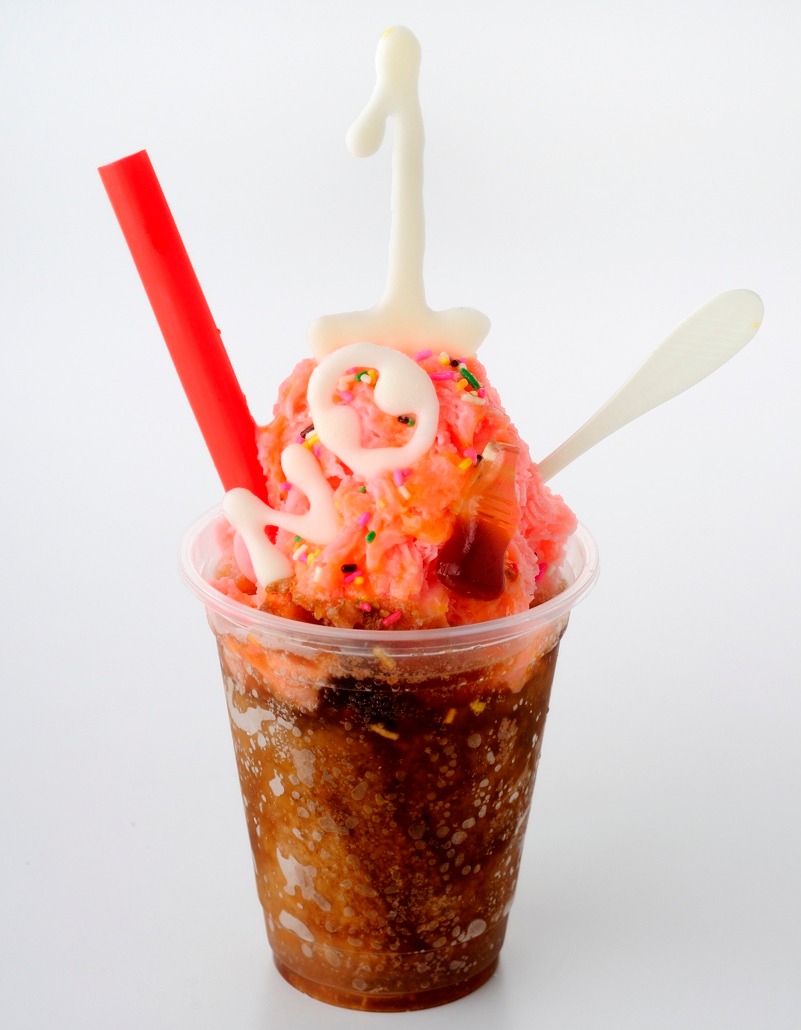 アメリカの「“Ｎｏ．１は俺だ！”シェイク」は、アイスクリームシティのマジックスノーで販売。アメリカが好きなシェイクとコーラのメニュー。上のふわふわの台湾カキ氷（ピンク）と、下のタピオカ入りコーラと混ぜ、シェイクにして食べるというもの。アメリカをイメージさせる“No.1”のホワイトチョコが添えられている。ちなみに“No.1”の“O”は宇宙人のトニーをイメージ。