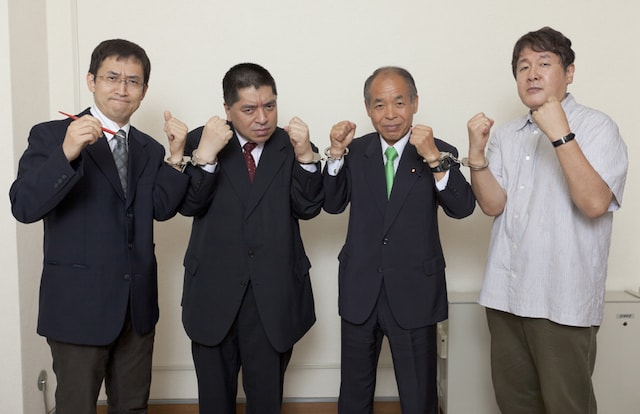 座談会の記念に、手錠でつながれる4人。左から伊藤潤二、佐藤優、鈴木宗男、長崎尚志。