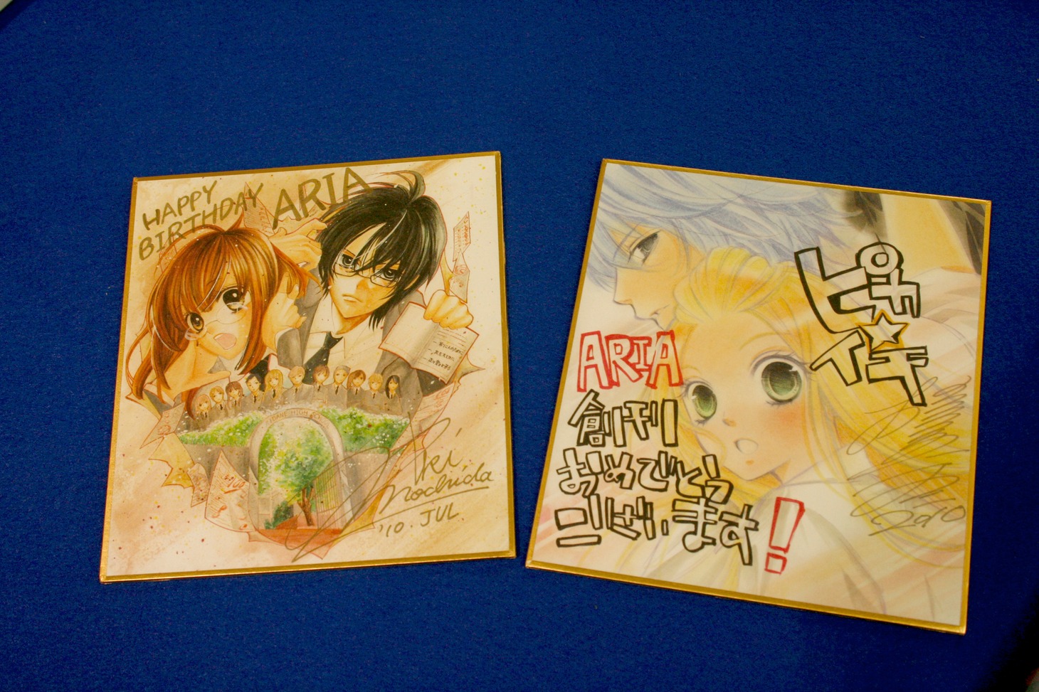 左が持田の、右が槙の描き下ろし色紙。