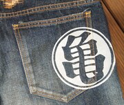 右後ろポケットのは「マル亀」マーク。(C)バードスタジオ/集英社・フジテレビ・東映アニメーション