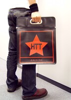 ハンドルが鉄で補強されているので、思う存分詰めこんでも安心。(c)かきふらい・芳文社/桜高軽音部 / (c)ディスクユニオン