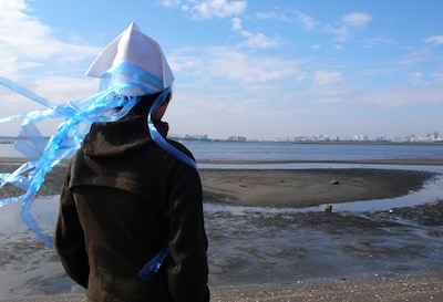 冬の海での「イカ帽子」着用例。ビニールテープは付属しないので注意。 (C)安部真弘（週刊少年チャンピオン）／海の家れもん