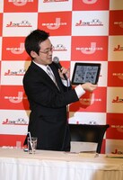 iPadを掲げ、「Jコミ」における絶版マンガ配信について説明する赤松。