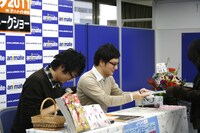 同人誌にサインを入れて渡すミサワ。