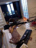 資料用に購入したライフルを担ぐ新條