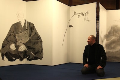 親鸞が描かれた屏風を見つめる井上。（3月26日に行われた発表記者会見より）