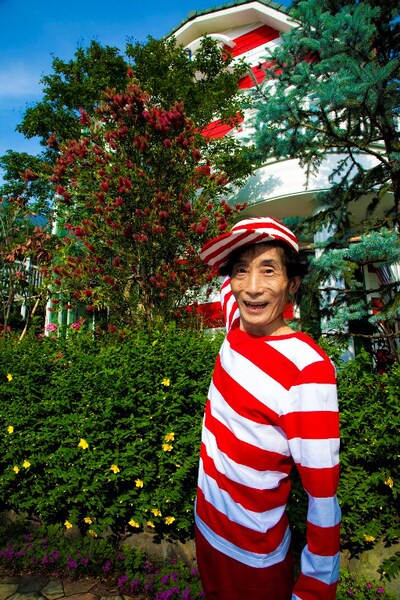 手前の赤白ボーダーを着た人物が楳図かずお。奥に見える、赤白ボーダーの建物が楳図ハウスだ。