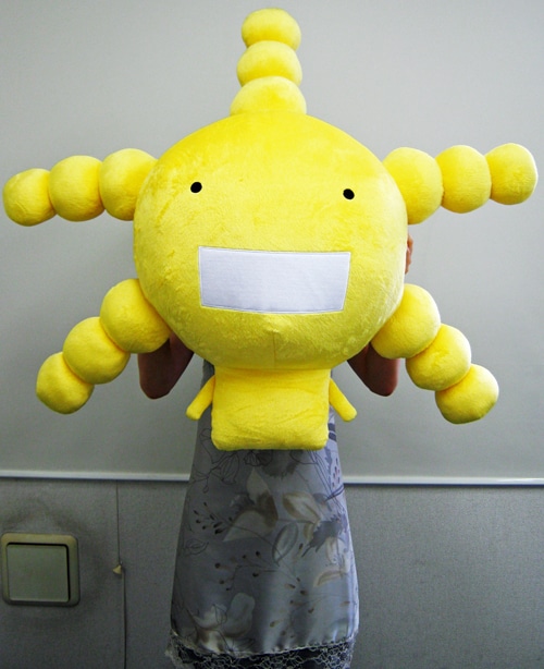 「巨大オリゼ―ぬいぐるみ」の大きさがよくわかる1枚。女性の上半身がほぼ見えなくなるほど大きい。