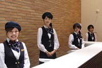 受け付けに立つ、笑顔の素敵なアテンダントたち。(c)Fujiko-Pro