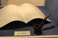 コマ割りの案が描かれたノートに、パイプを添えて。(c)Fujiko-Pro