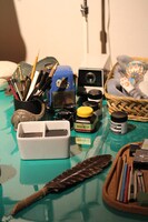 机の上には画材のほかオモチャ、資料の本などが置かれている。(c)Fujiko-Pro