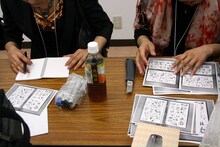 控え室にて急遽おみやげ用のペーパーを作り始める森薫と入江亜季。