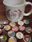 抽選でプレゼントされるマグカップとバッジ。