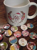 抽選でプレゼントされるマグカップとバッジ。