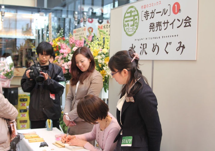 サイン会の様子。水沢は1人1人と会話しながら丁寧にサインを入れていく。