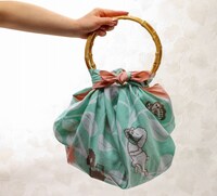 「大判風呂敷 オチビとシロツメ草」はかばんとして使うことも。 ※写真のリングは、商品には含まれておりません OCHIBISAN (c) ANNO MOYOCO