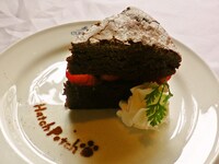 日替わりケーキのお皿には「はちぽち」の足跡マークをステンシル。ケーキの種類は、店頭で確認を。(C)異識・芳文社／あっちこっち製作委員会