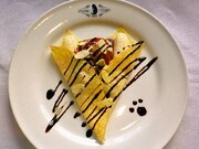 みいこさん直伝「はちぽち」人気のクレープをイメージしたオリジナルメニュー。チョコアイス、バナナ、ココアプリンなどを盛り、猫の顔をかたどった。(C)異識・芳文社／あっちこっち製作委員会