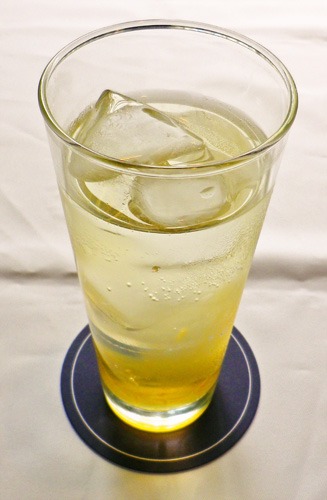 戌井榊をイメージしたドリンク。オレンジシロップ×ソーダ×ジャスミンティーの味わい。(C)異識・芳文社／あっちこっち製作委員会