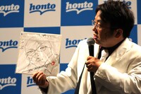 板垣のサイン色紙を自慢する天野ひろゆき。