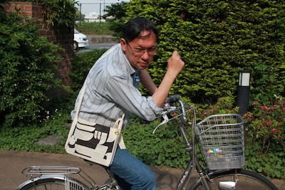 特製サコッシュを身につけるコミックビームの奥村編集長。