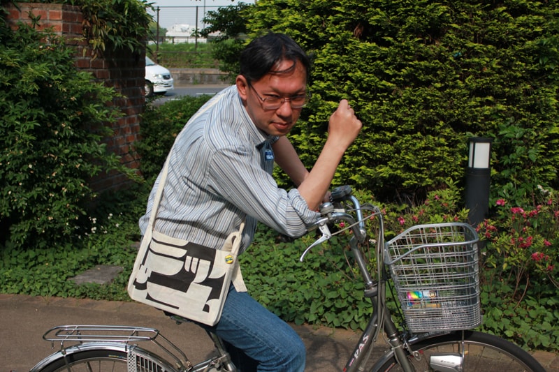 特製サコッシュを身につけるコミックビームの奥村編集長。