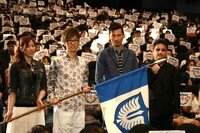 鷹の団の旗を掲げる4人。（左から）キャスカ役の行成とあ、グリフィス役の櫻井孝宏、ガッツ役の岩永洋昭、窪岡俊之監督。