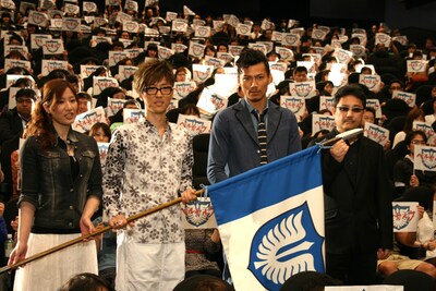 鷹の団の旗を掲げる4人。（左から）キャスカ役の行成とあ、グリフィス役の櫻井孝宏、ガッツ役の岩永洋昭、窪岡俊之監督。