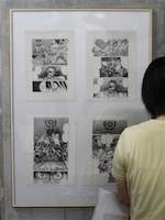 原画展の風景。1パネルに4枚のマンガ原稿を入れ、ストーリーの流れを追いながら原画が見られる仕組みになっていた。