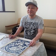 「キン肉マン サイン入り木版画 第21回超人オリンピック NAVY」にサインを入れる嶋田隆司。