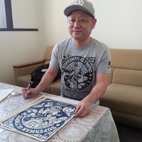 「キン肉マン サイン入り木版画 第21回超人オリンピック NAVY」にサインを入れる嶋田隆司。