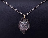 髑髏の騎士のコイン型シルバーペンダント。（c）三浦建太郎(スタジオ我画)/白泉社