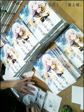 「屋上姫」4巻にTOBIがサインする様子。