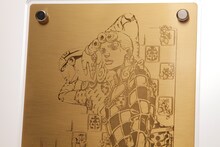 「黄金体験BOX」に付くアートプレート。(C)荒木飛呂彦＆LUCKY LAND COMMUNICATIONS／集英社 (C)2013  NBGI