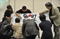 ボードにサインを入れる一同。