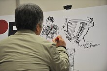 ボードにサインを入れる大友克洋。