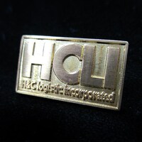 「真鍮ピンバッジセット」のHCLIロゴ。 (C)2012 高橋慶太郎・小学館／ヨルムンガンド製作委員会