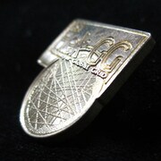 「真鍮ピンバッジセット」のHek-GGマーク。 (C)2012 高橋慶太郎・小学館／ヨルムンガンド製作委員会